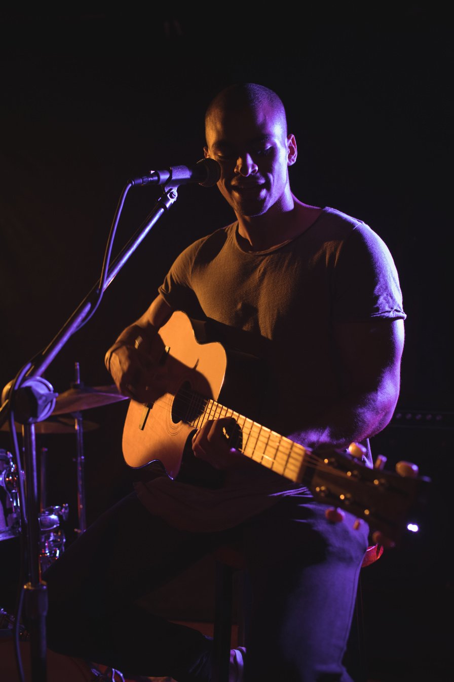 Confident male singer playing guitar